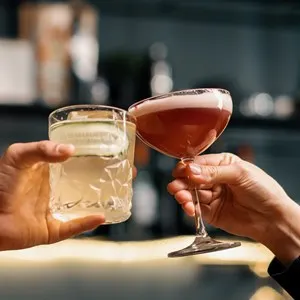 Close up of two people cheering cocktails in bar or disco club drinks and cocktails concept
