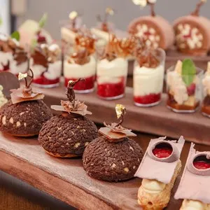 French patisserie. Chocolate choux pastries on wooden stand in confectionery shop