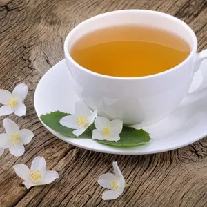 Cup of green tea with jasmine flowers