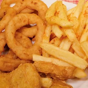 Plate with onion rings and French fries with nuggets