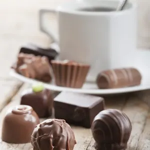 assorted chocolates confectionery with cup of coffee
