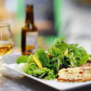 Traditional French food: quiche lorraine and fresh salad leaves with glass of beer. Healthy meal. Lunch or dinner with organic vegetables. Typical European local farmer market - Bild