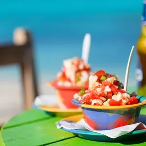 Two bowls of Bahamian conch salad and bottle of beer.