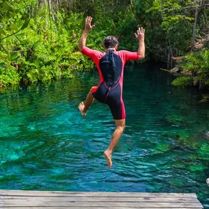 man jumping into a cenote in the Riviera Maya