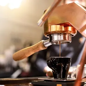 Barista making hot espresso coffee with the coffee machine in the coffee shop or cafe.