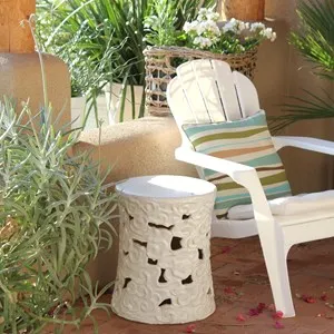 Outdoor deck decor with palm tree, white geraniums in a basket, butterfly lilies, succulents, white glazed pottery side table and white chairs and plants on a sunny day in the Tucson Arizona