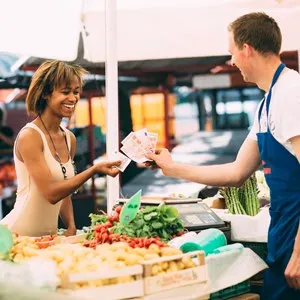 Young woman paying for produce at farmers market
