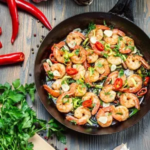 Fresh vegetables and shrimps on old pan