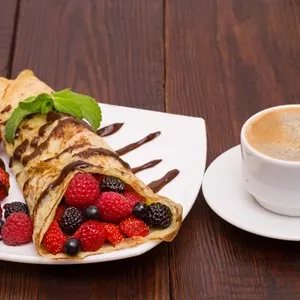 Crepes With Berries and cup of coffee