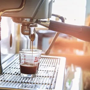 Close-up of espresso pouring to cup from coffee machine
