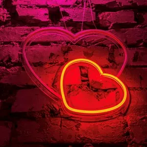 Neon hearts glow warmly against a rustic brick backdrop