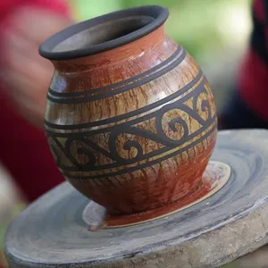 An artist makes a clay vase on a pottery wheel in Costa Rica
