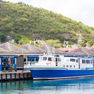 A large blue and white ferry tied to a dock at the port of Marigot on the French side of St Martin
