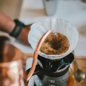Barista brewing coffee with pour over method
