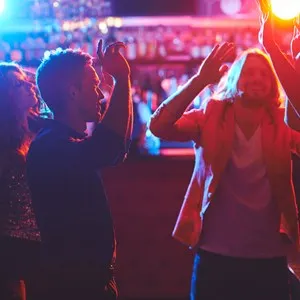 Friends dancing by the bar counter