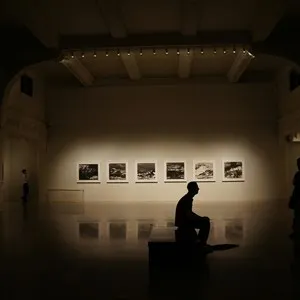 Silhouette of Person Sitting on Bench at a gallery