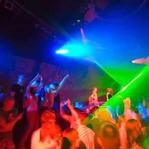 Party at Disco concert full of young people dancing in music and laser show