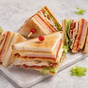 Club sandwich with ham, cheese, tomatoes, lettuce, and toasted bread