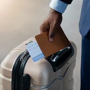 Business Travel Concept. Businessman Holding Passport And Boarding Pass Standing With Suitcase At Airport. Closeup, Selective Focus, Panorama