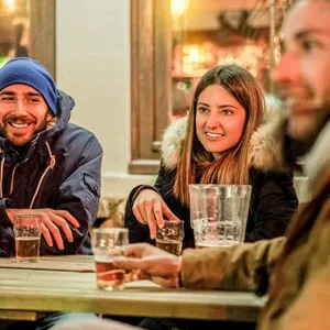 friends toasting beers at chalet pub restaurant in mountains on evening time