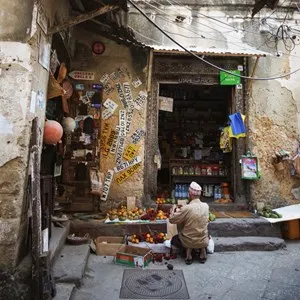 old man in front of his shop that sells knick-knacks