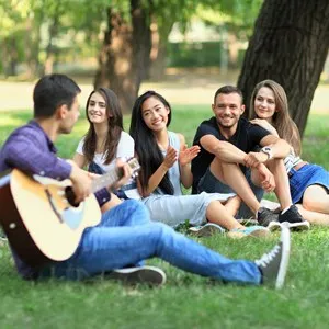 Group of friends resting in park on sunny day