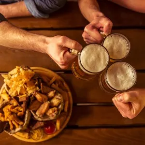 Top view of hands clanging glasses of beer together