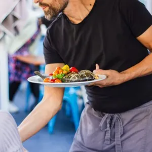 server bringing a fish dish to the table