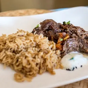 Shuwa - a traditional Omani dish where meat is marinated in spices, wrapped in palm or banana leaves and then cooked underground - served with rice