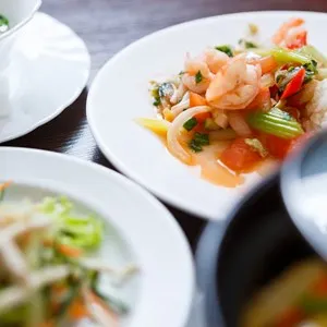 exotic Vietnamese salad with boiled shrimps,fresh vegetables and white rice served on a white plate