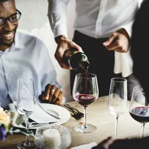 Restaurant Staff Poring Serving Red Wine to Customers