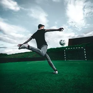 man kicking a football