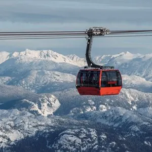 ski gondola with mountains in the background on a cloudy winter day