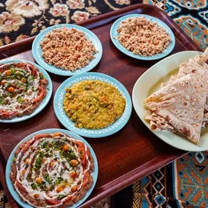 Delicious dishes of traditional omani food served on carpet in traditional restaurant, Oman