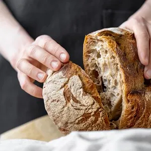 woman holding fresh bread from the oven