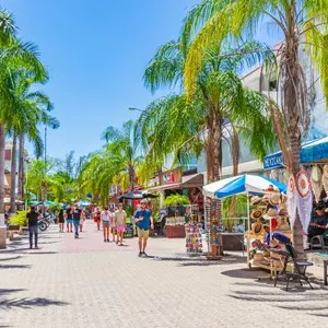 Typical street road and cityscape of La Quinta Avenida with restaurants shops stores people souvenirs and buildings of Playa del Carmen in Quintana Roo Mexico.
