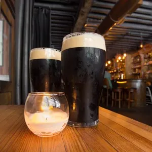 Dark beer and candle in pub setting