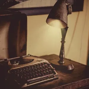 desk lamp and typewriter on a wooden table