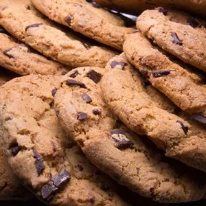Chocolate chip cookies stacked up on a plate, ready to be served.