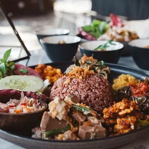Nasi Campur, asian dish made of brown rice and mixed variety of vegetables, tofu, tempeh, fritters and sauces, asian Indonesian cuisine, food culture, spicy