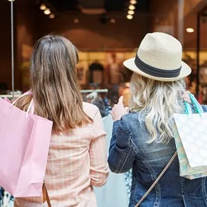 Two women shopping as customers in front of a retail boutique