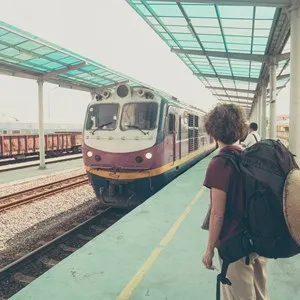 Woman backpacker waiting train on platform at station in Vietnam