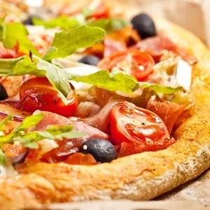 Pizza with dry cured ham and basil