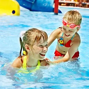 Children on water slide at aquapark. Summer holiday