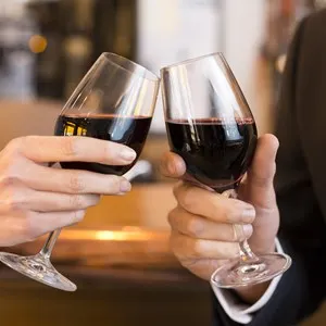 Close Up of Couple Toasting with red wine glass in restaurant