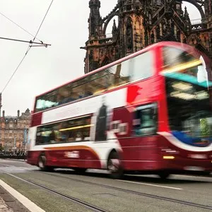 Blurry two-deck bus in the city center of Edinburgh, Scotland in the evening