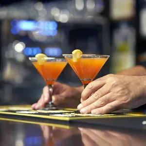 Barman gives red cocktail to the client