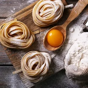 Raw homemade pasta and ingredients for pasta on wooden background