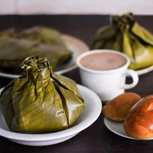 Closeup of delicious colombian tamales, with fresh bread and coffee