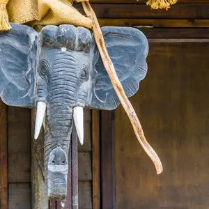 Elephant head sculpture hanging on a wooden pole